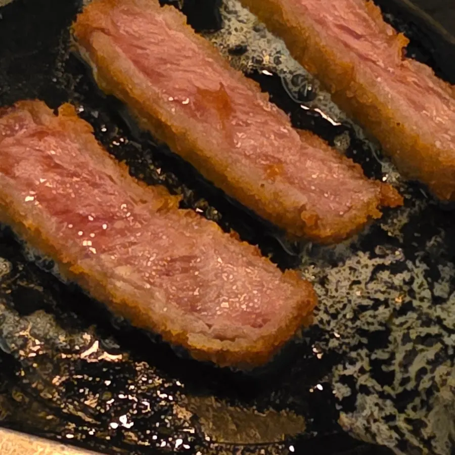 A piece of sirloin gyukatsu placed on the stove