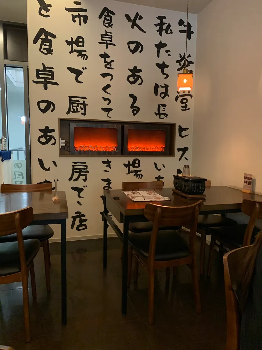 Interior of Gyuen-dang decorated with wood tones and a Japanese-lettered mural