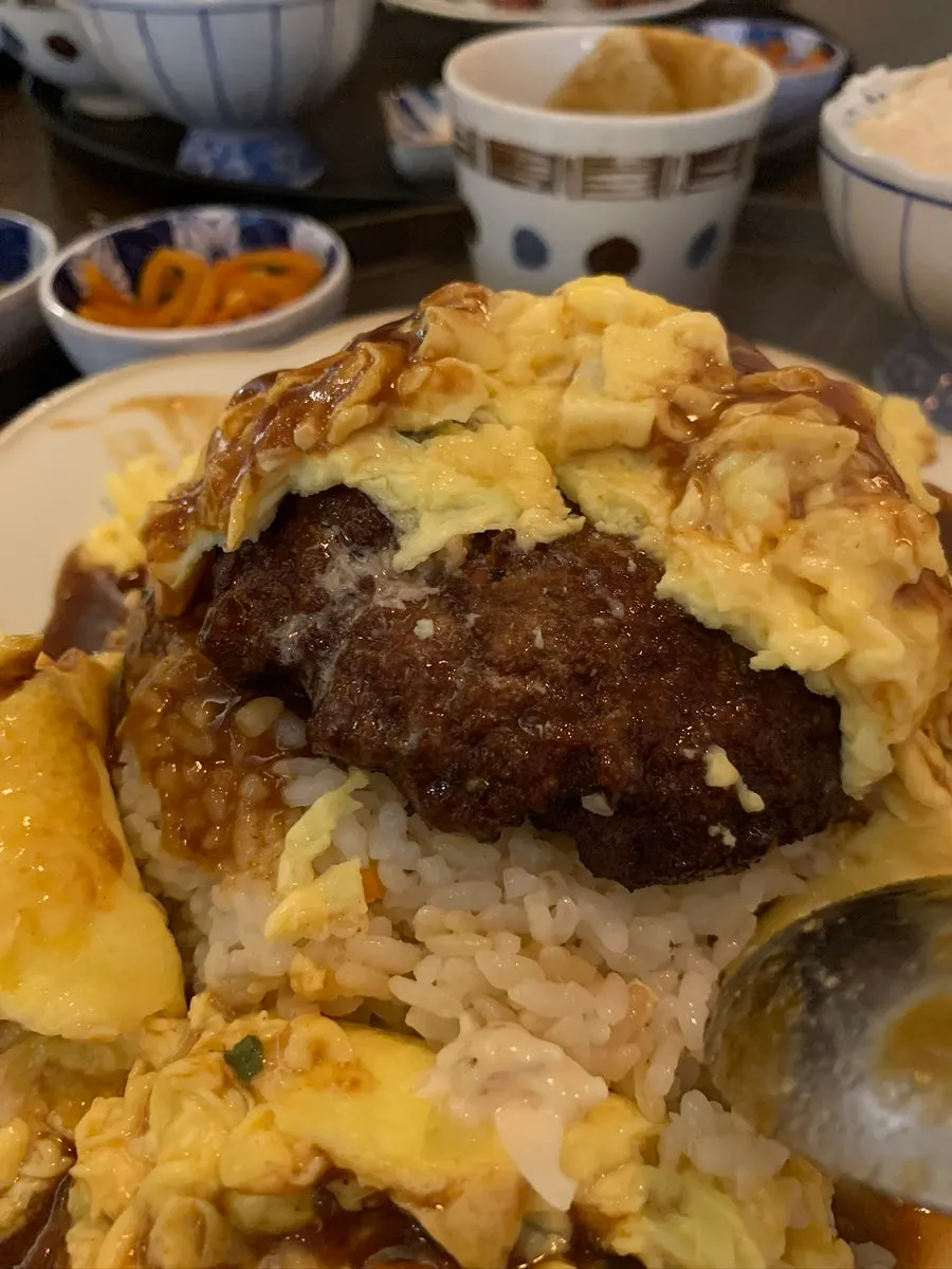 Thick hamburg steak revealed underneath the egg