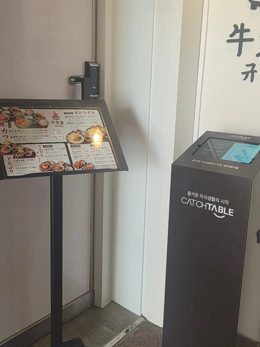 CatchTable waitlist kiosk and menu board at the entrance