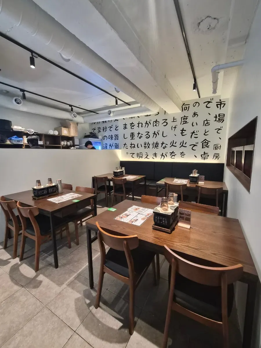 Interior of Gyuen Dang Seolleung Branch with white walls and wood tables