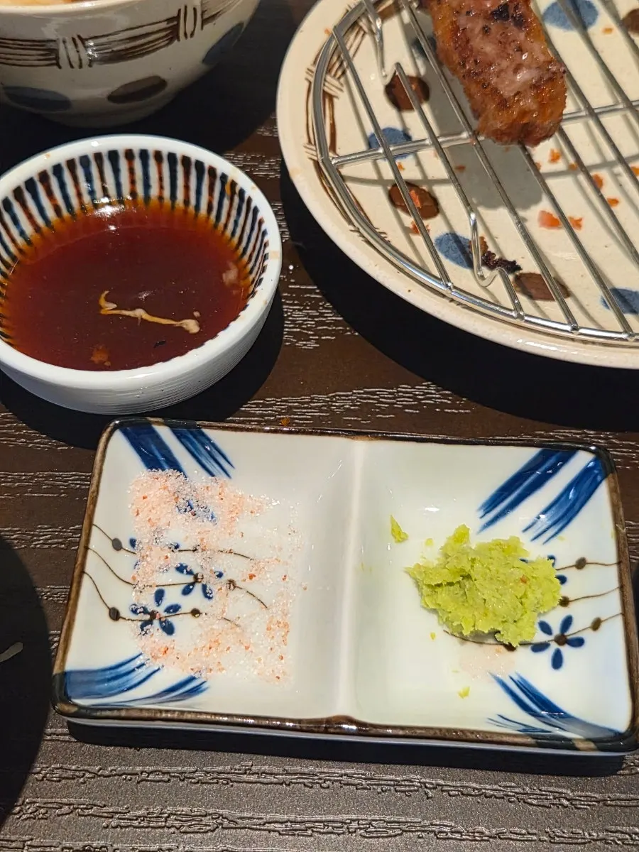 A piece of gyukatsu topped with salt and wasabi