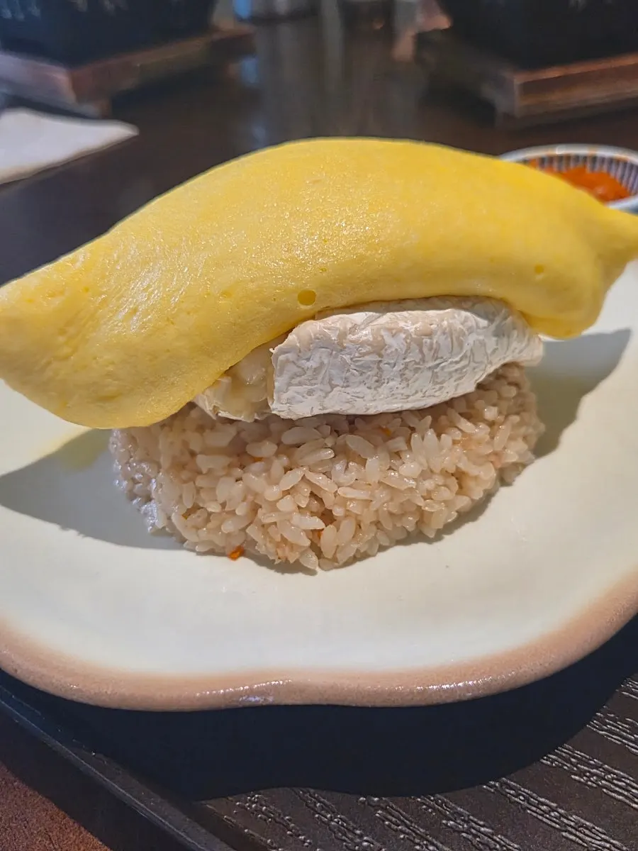 Close-up of the brie cheese omurice wrapped in egg