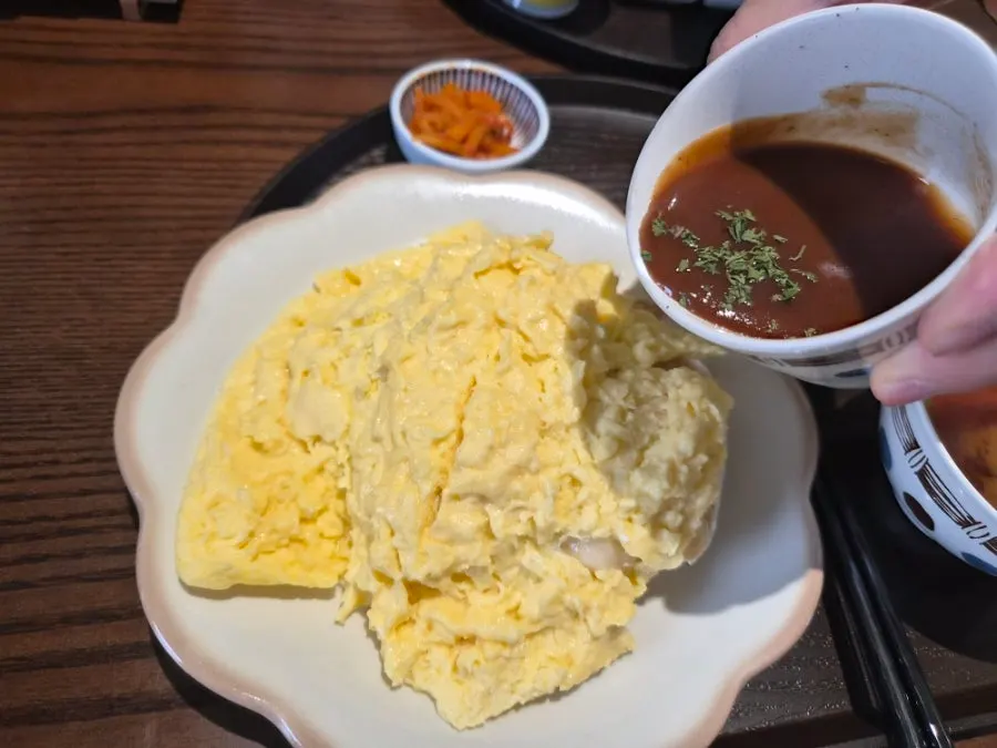 Omurice with the egg split open and sauce drizzled on top