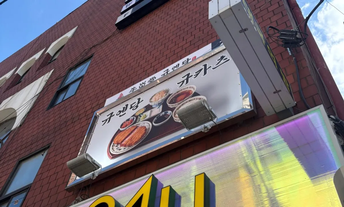 Exterior of Gyuen Dang in a red brick building at the entrance to the Seolleung Station restaurant street