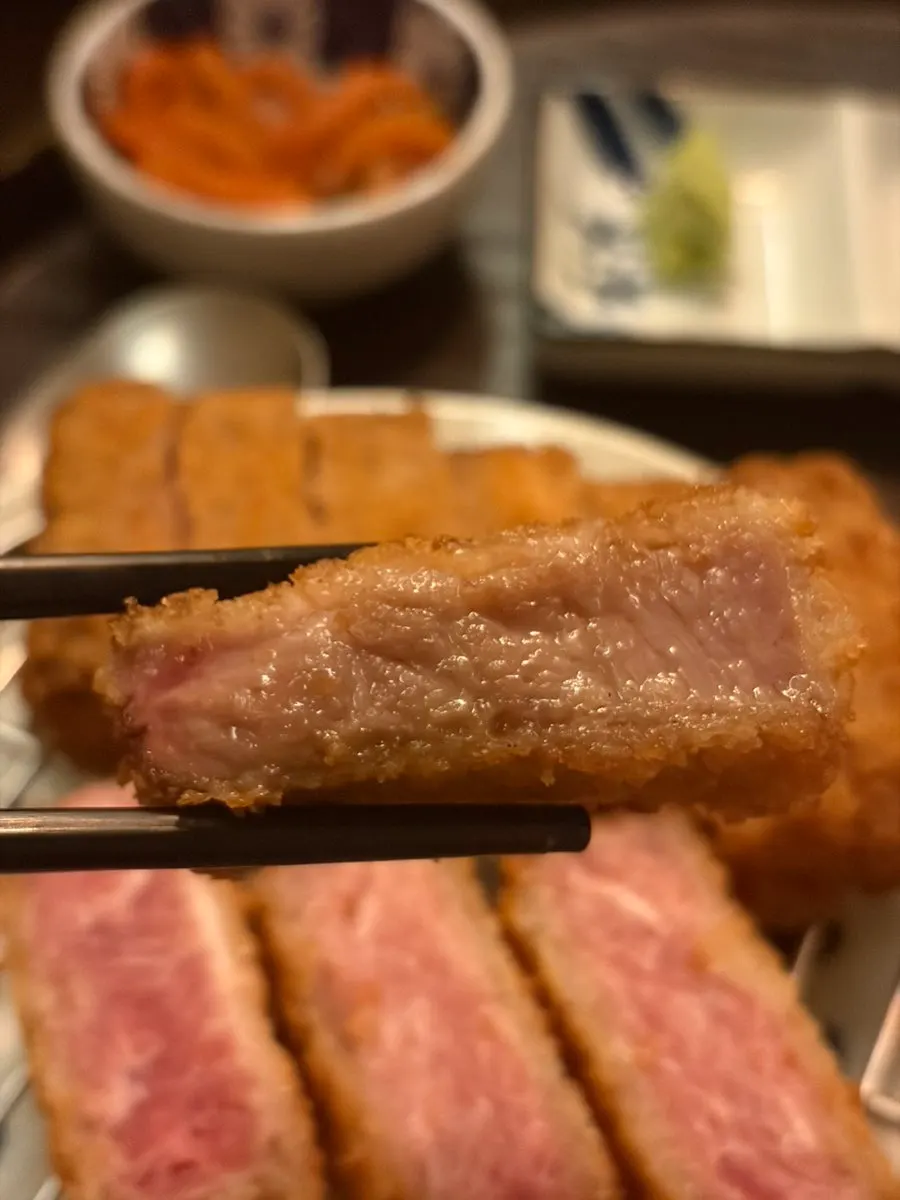A piece of gyukatsu grilling on the brazier