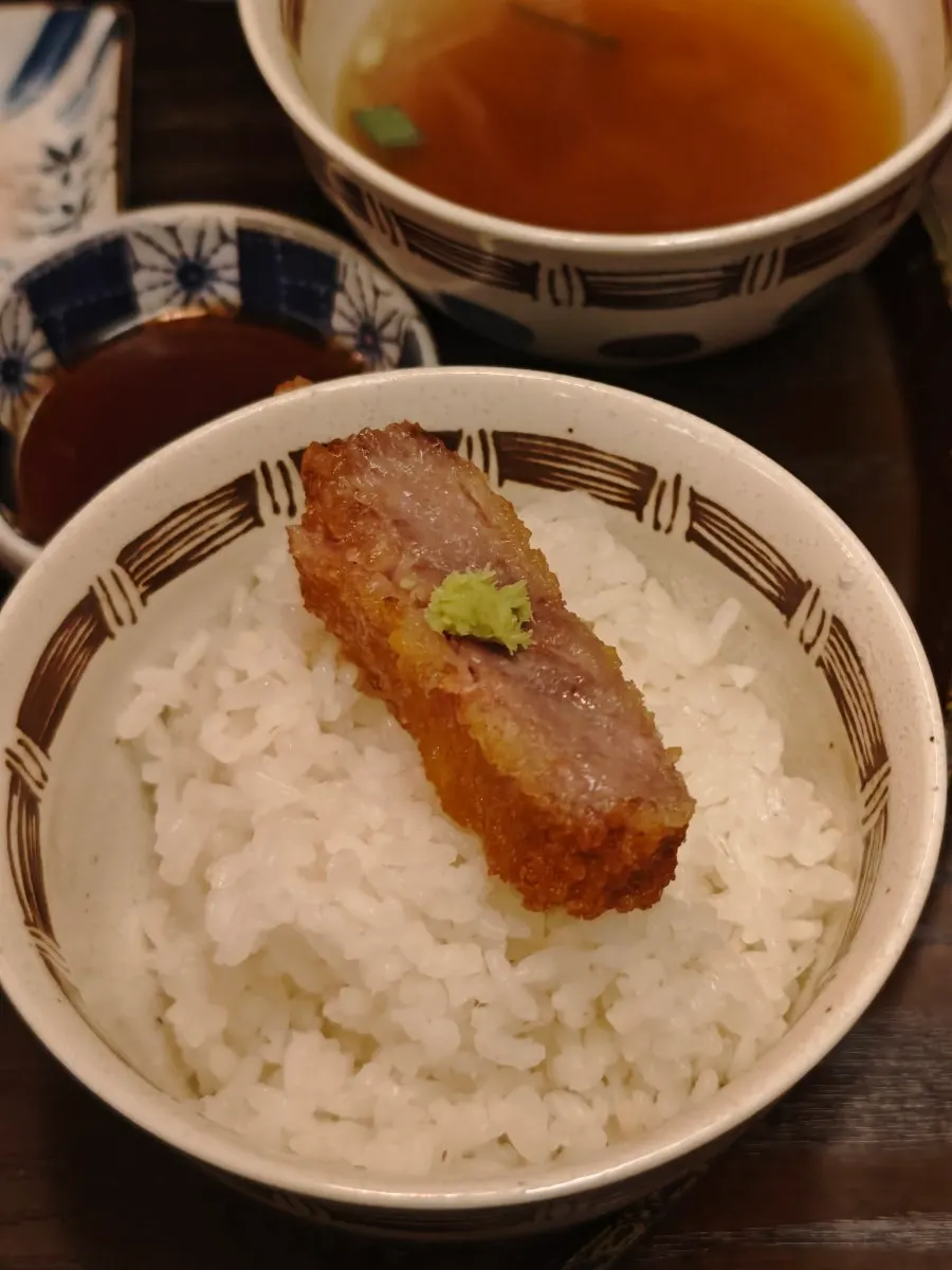 A piece of gyukatsu with wasabi and salt