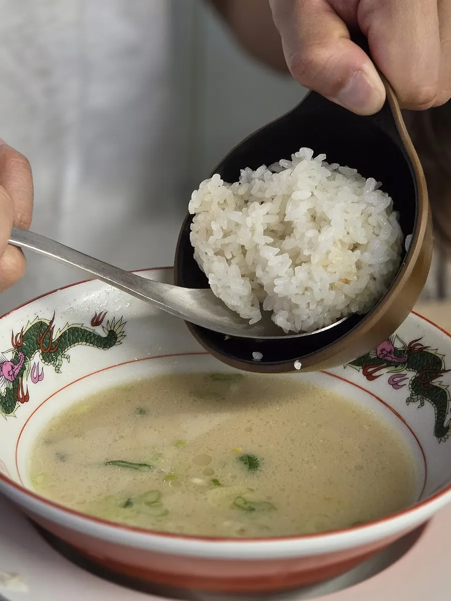 Spoonful of ramen topped with soft-boiled egg and chashu