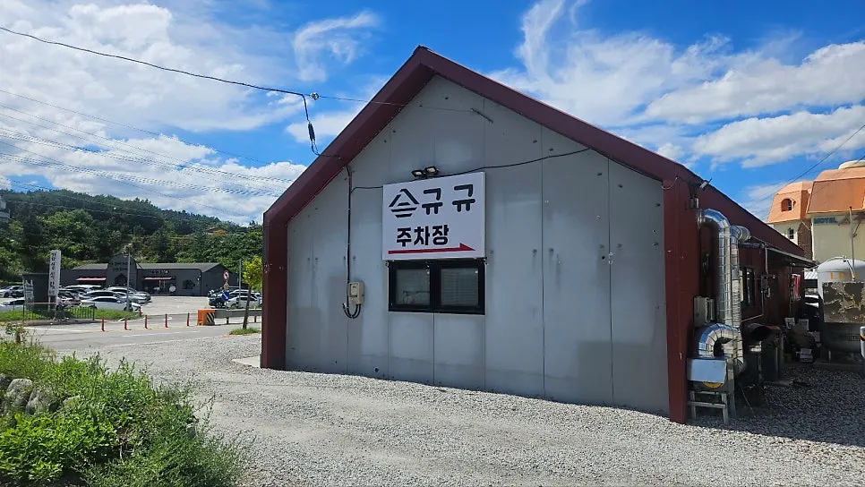 건물 뒤편 넓은 자갈 마당 주차장