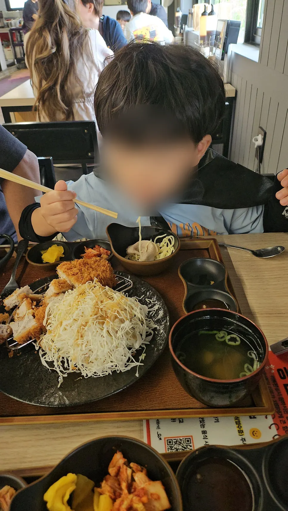 일회용 앞치마를 두르고 라멘 먹는 아이