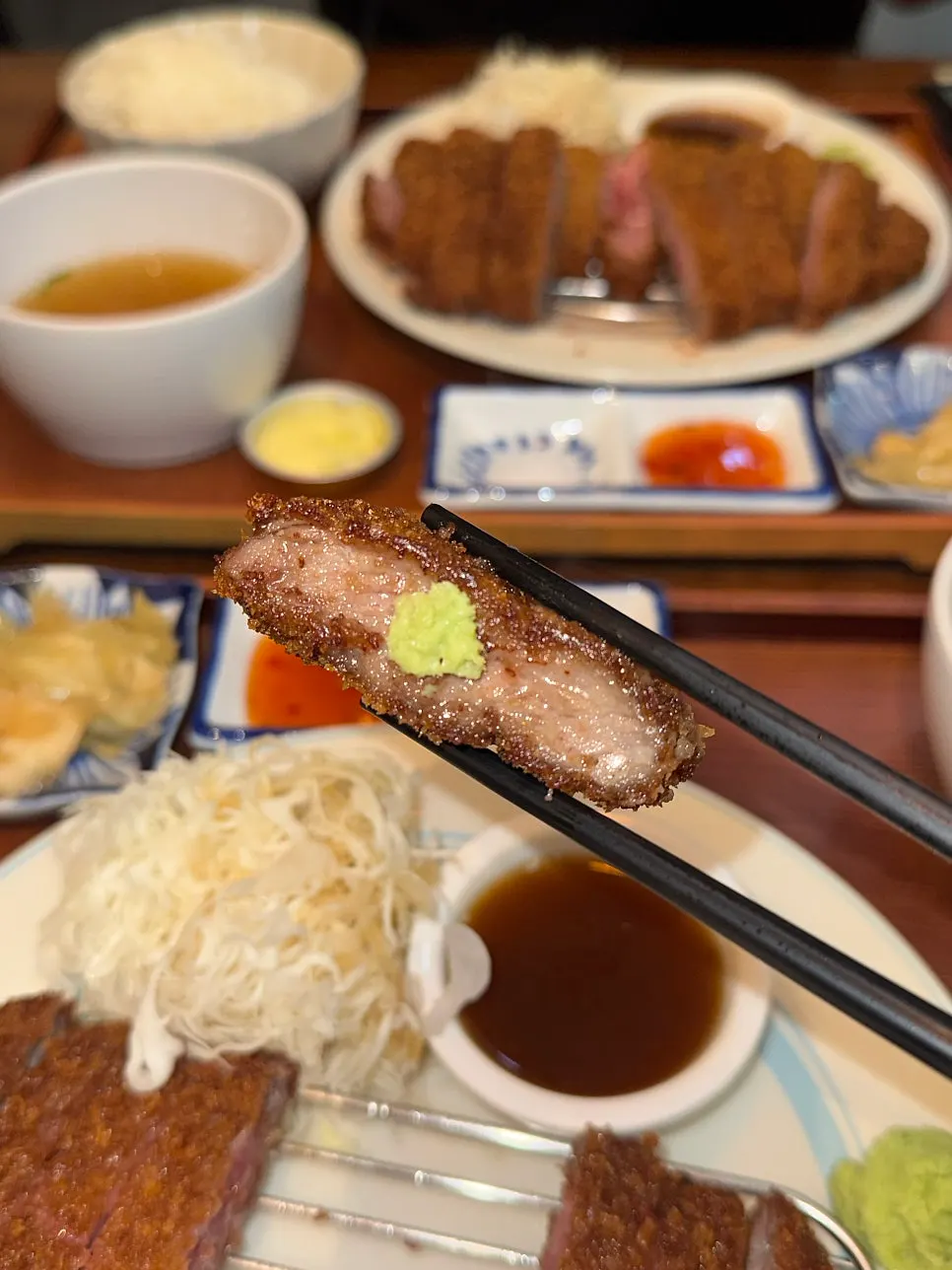 A slice of gyukatsu topped with wasabi