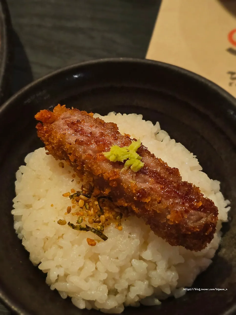 A piece of gyukatsu with salt and wasabi