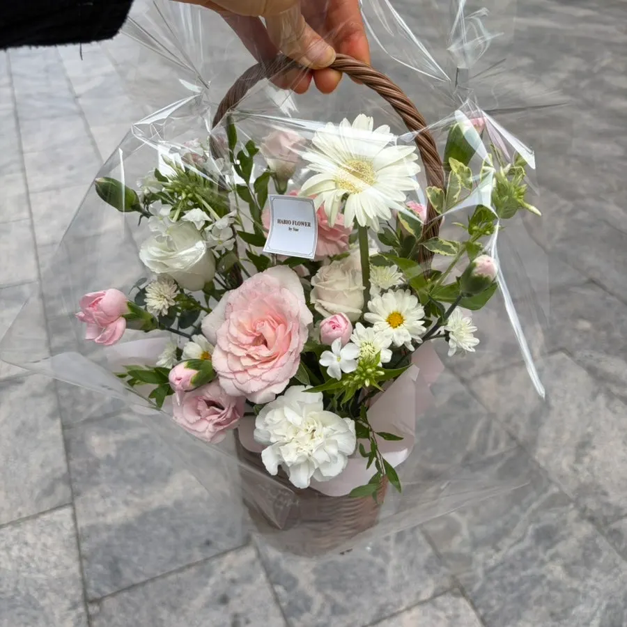 Flower basket wrapped in plastic with a carrying handle