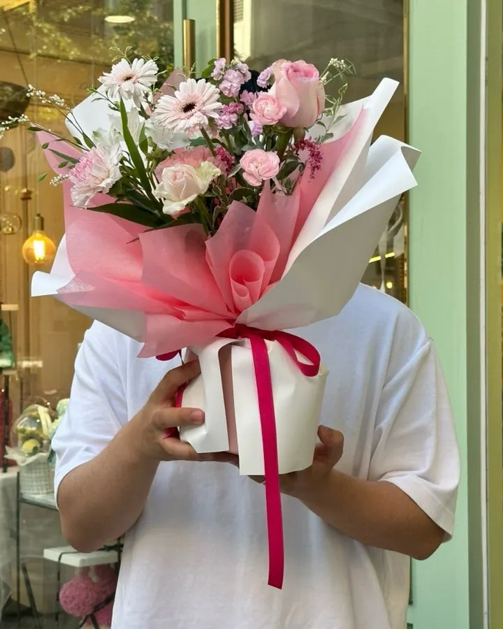 Husband holding the bouquet in front of the flower shop
