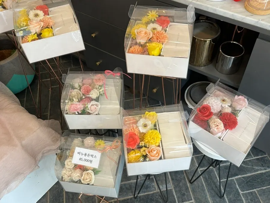 Shelf display of soap flowers and potted plants