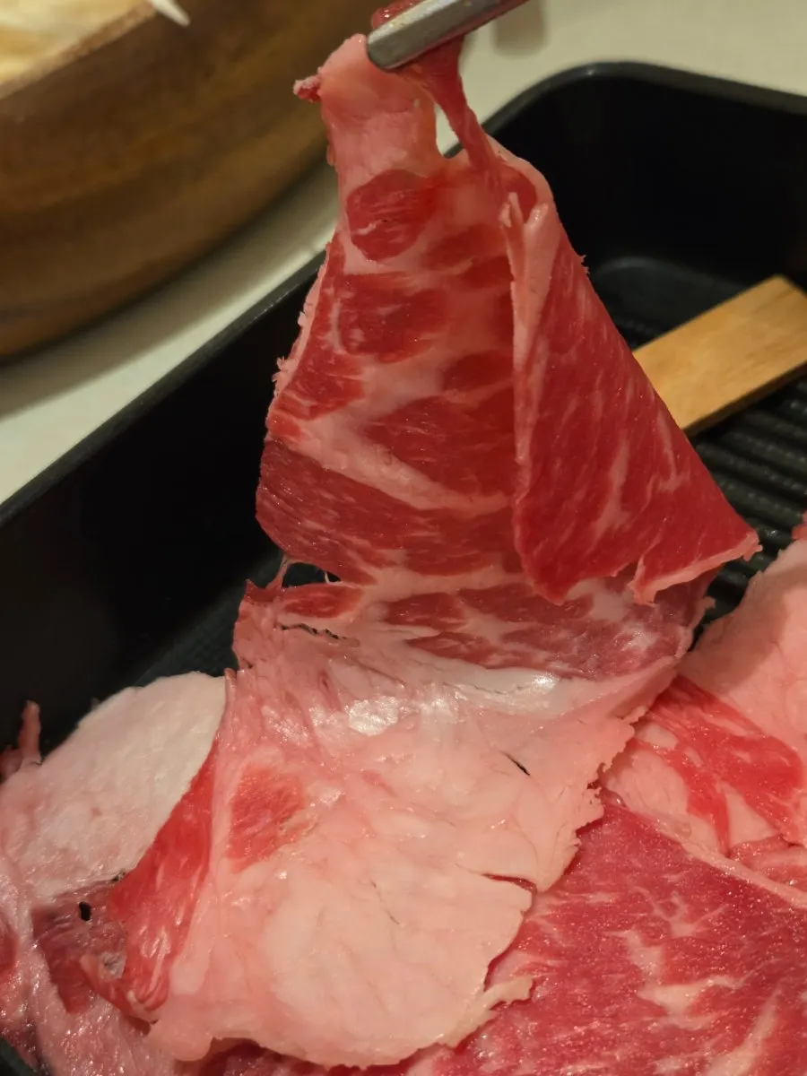 A slice of chuck flat lightly cooked in spicy mushroom broth