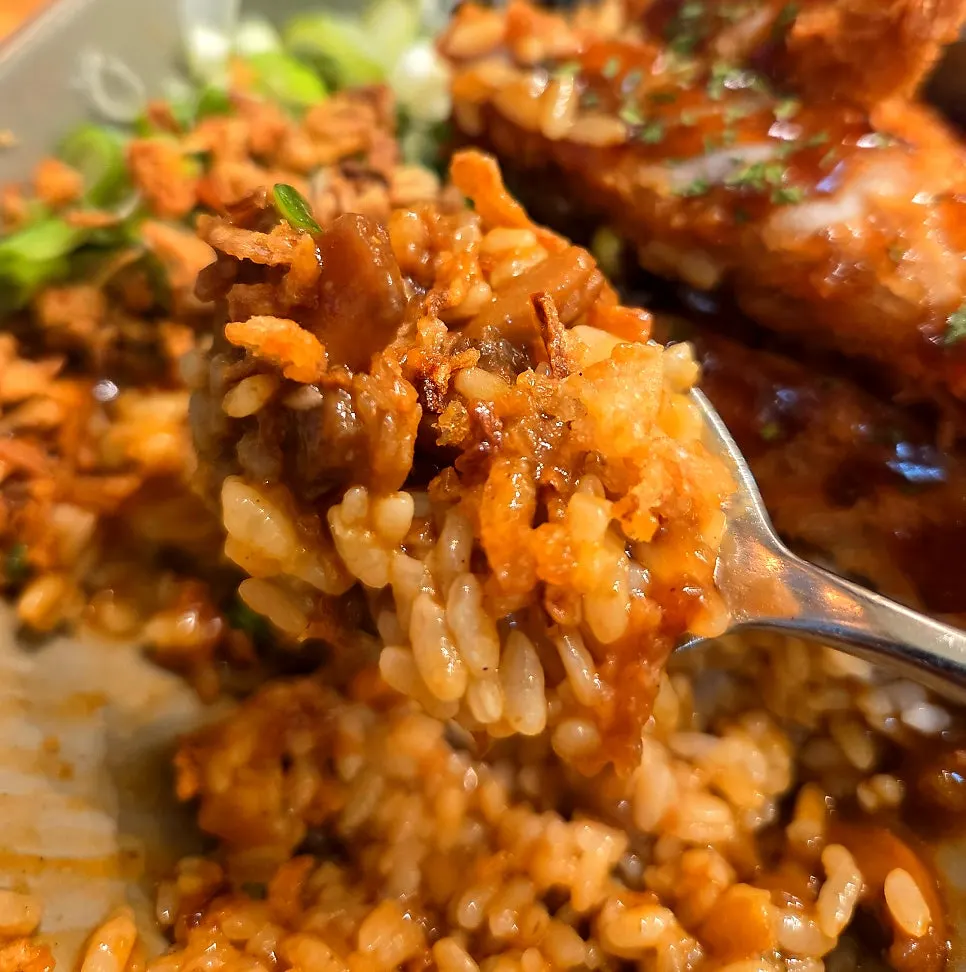 A spoonful of tonkatsu curry topped with flakes