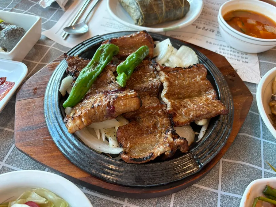 Wood-fired pork galbi served on a hot stone plate
