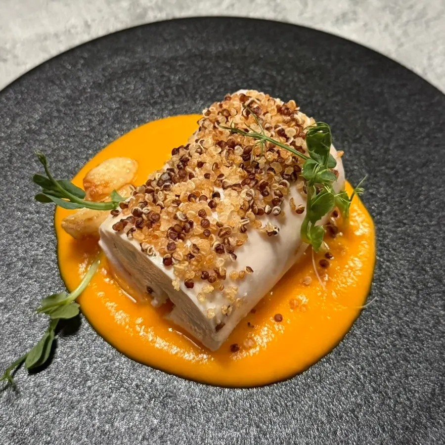 A bite of chicken breast with carrot sauce