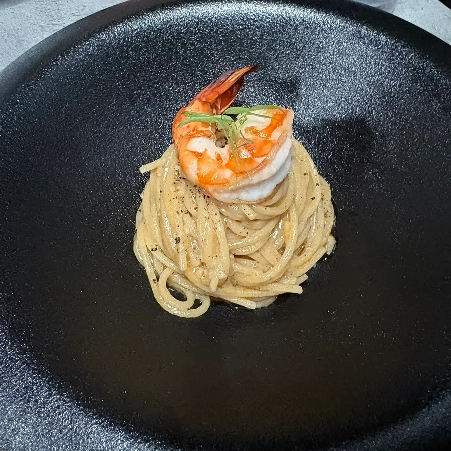 Bisque pasta plated in a tall rolled pile