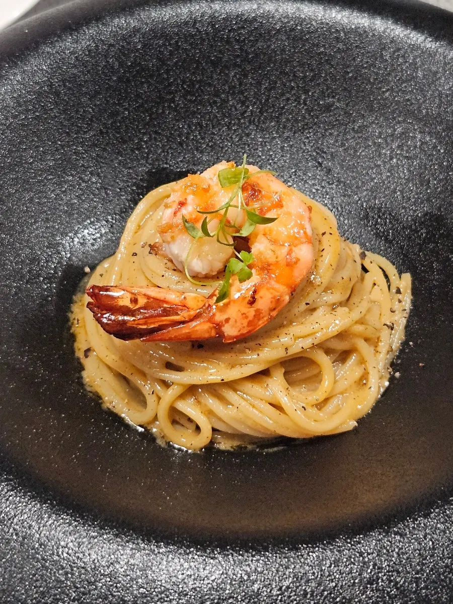 Bisque pasta topped with a large shrimp