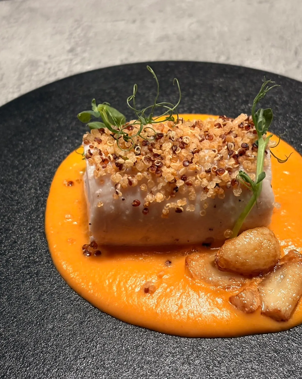 Sous vide chicken breast with grain topping and carrot sauce