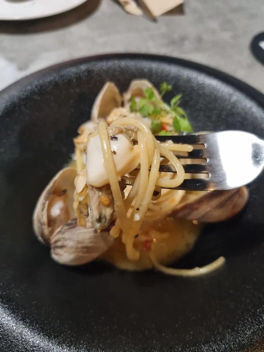 A plate of vongole pasta piled generously with clams
