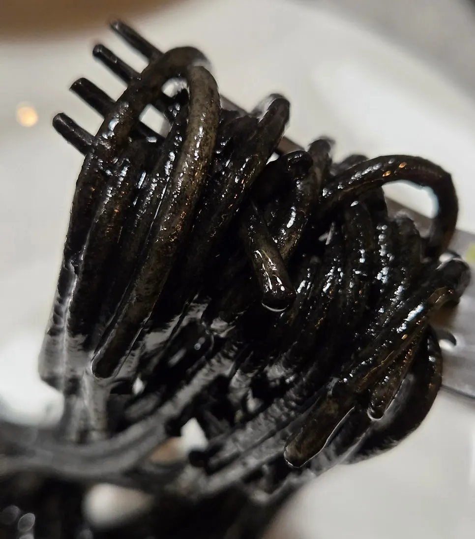 Squid ink pasta topped with baby octopus