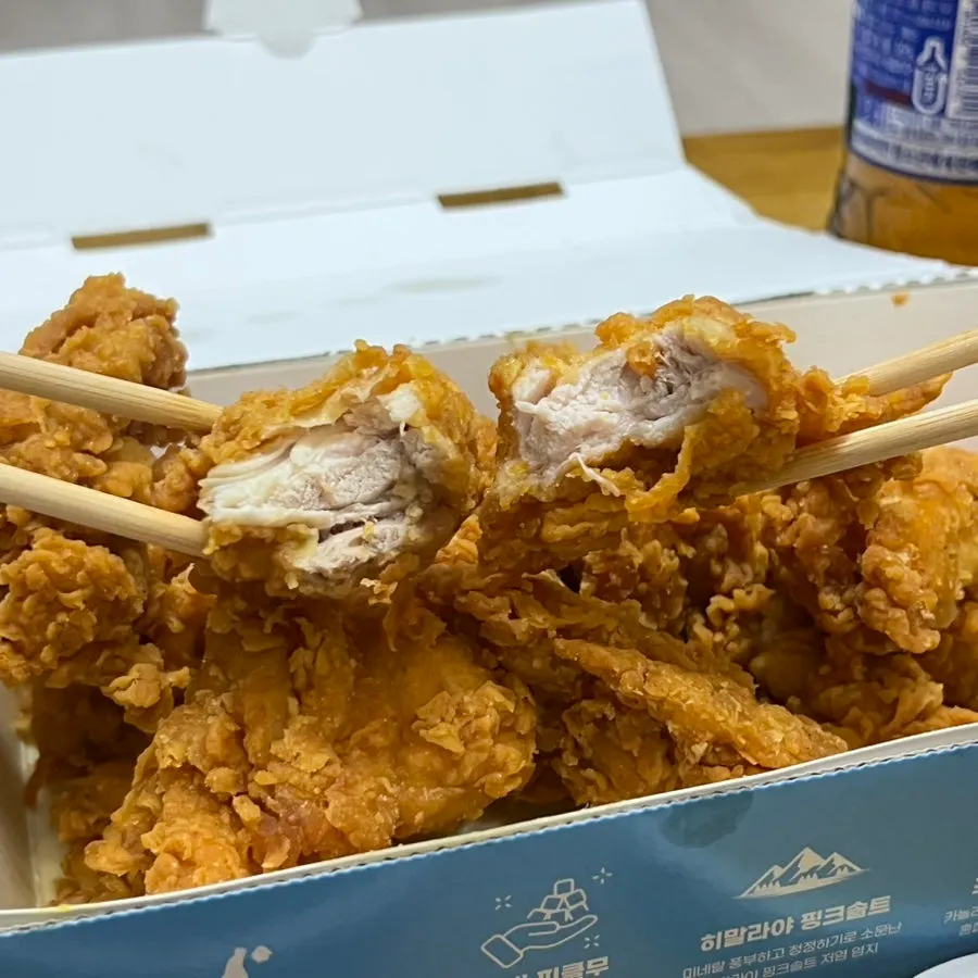 순살치킨 한 조각을 집어 든 모습