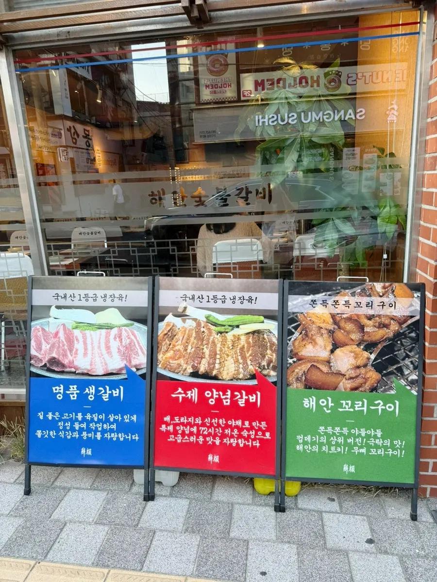 해안숯불갈비 대표 메뉴 사진이 담긴 입간판