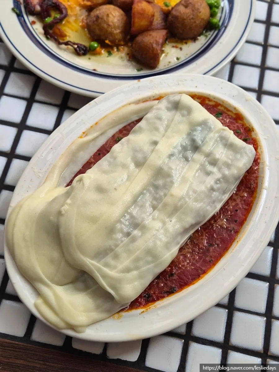 Aligot cheese being added to lasagna