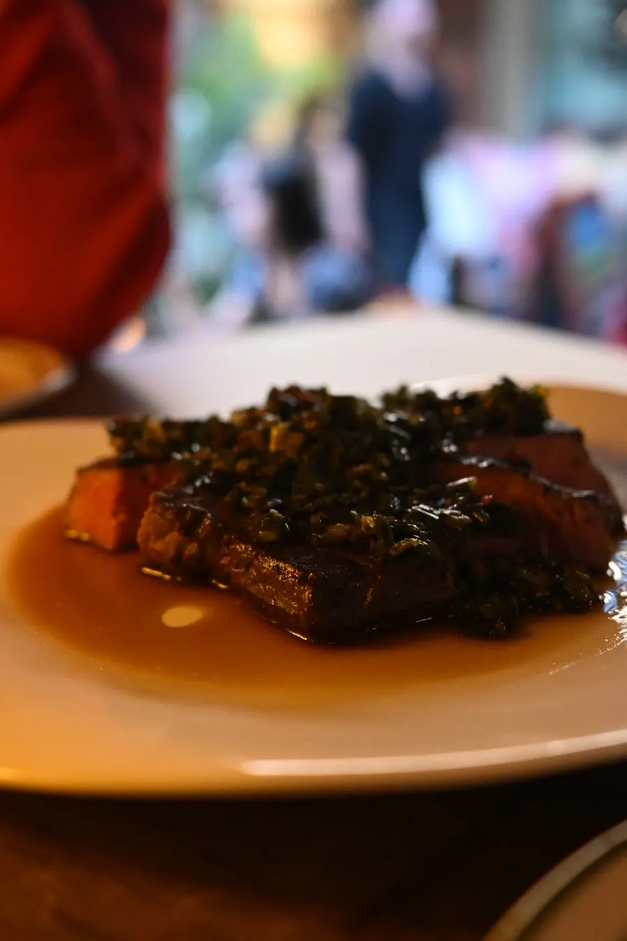 Sous vide steak topped with green onion and sauce