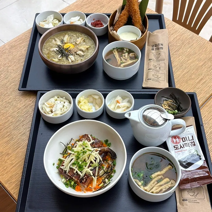 A full spread of eel rice bowl and abalone porridge neatly arranged on a tray
