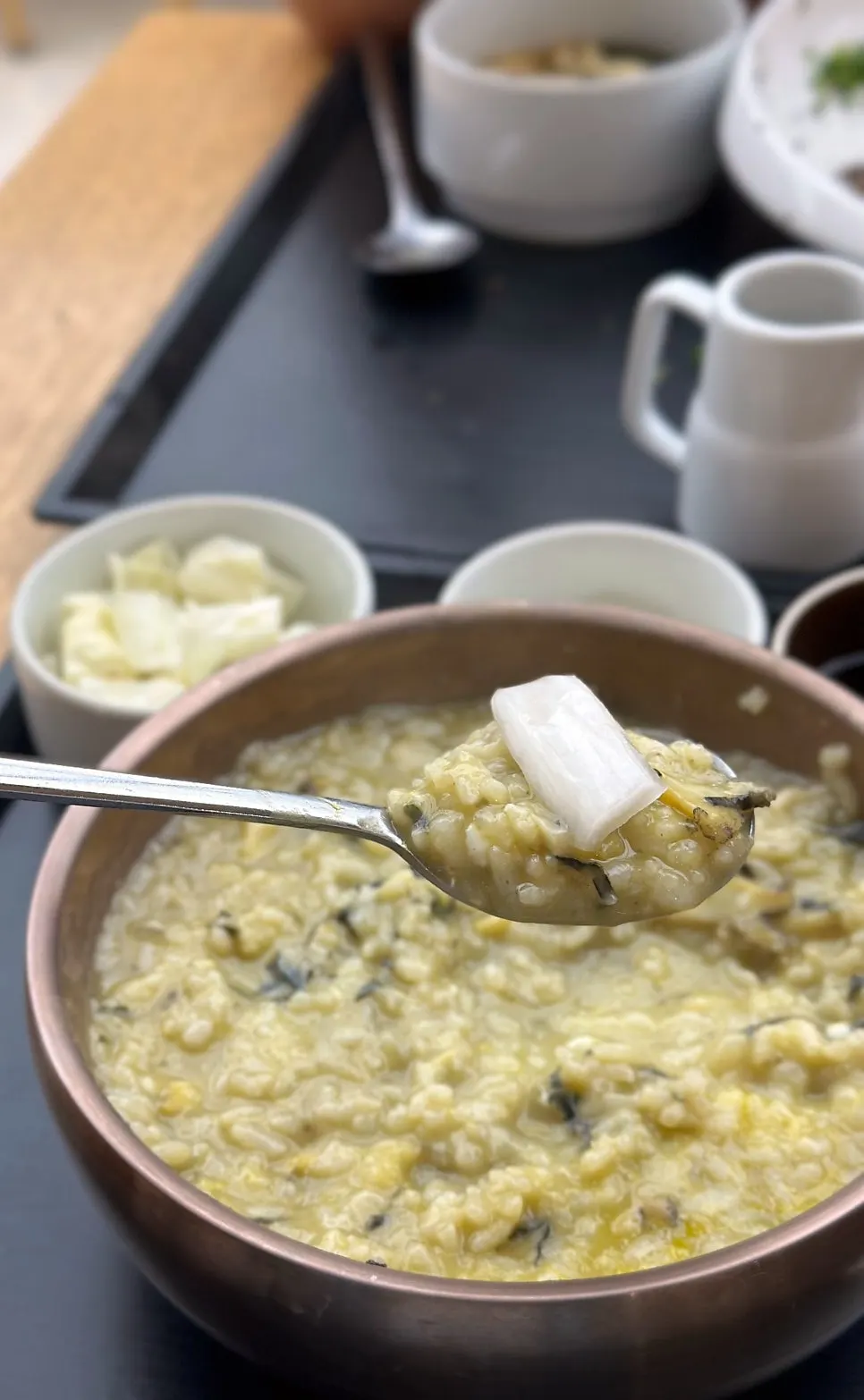 Spoonful of abalone porridge showing julienned abalone