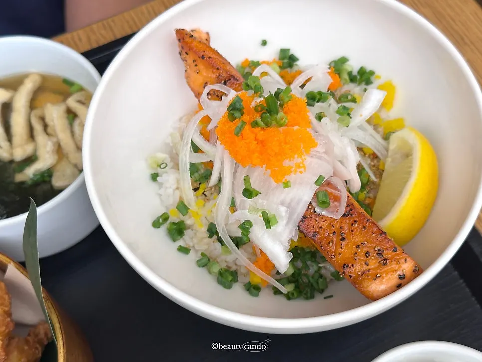 Grilled salmon topped with scallions on the salmon rice bowl