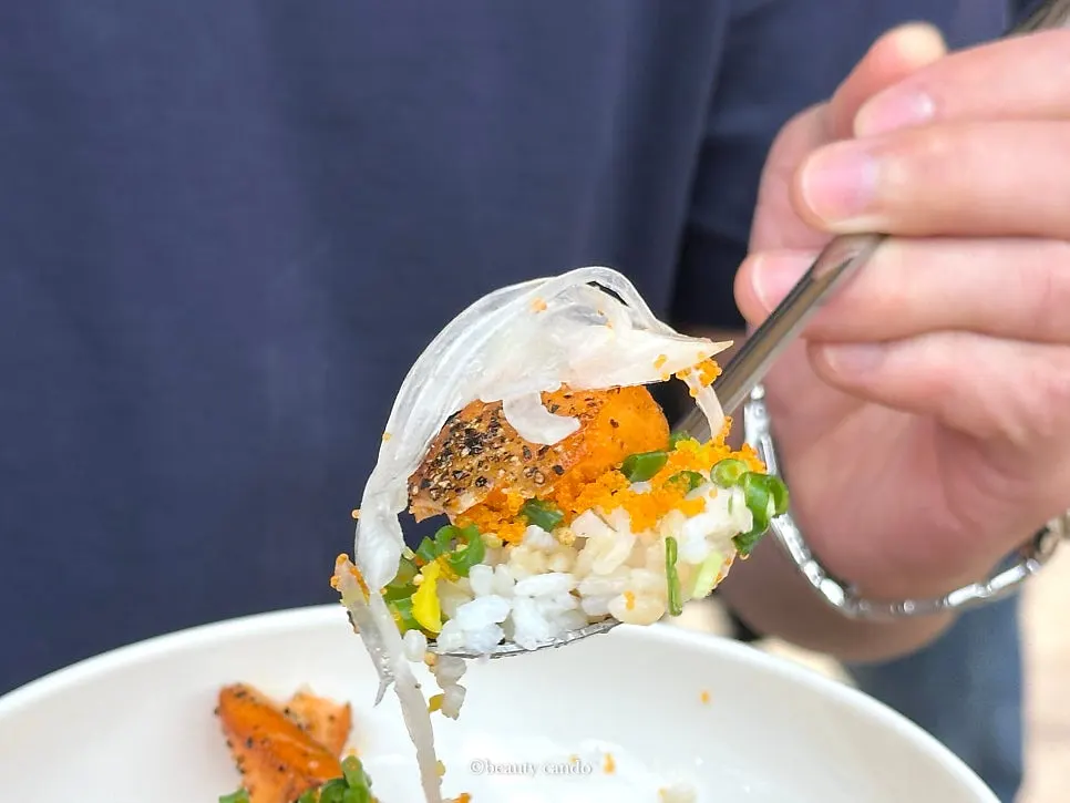 Salmon mixed together with rice in the salmon rice bowl