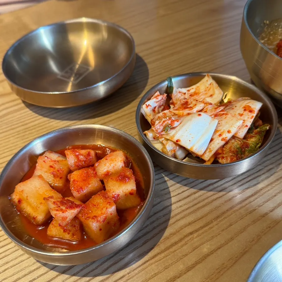 Kimchi and kkakdugi served in brassware bowls