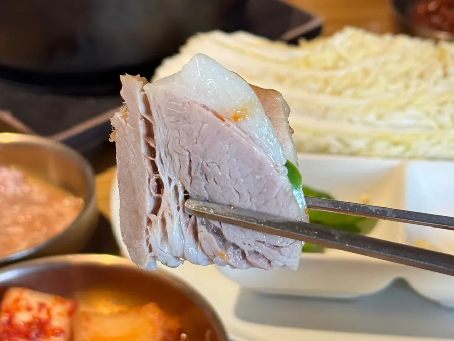 A piece of bossam meat topped with pollack sashimi