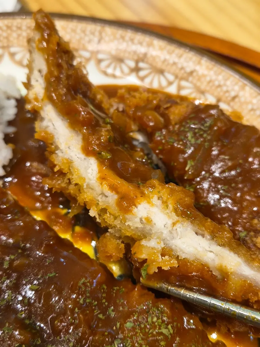 A piece of pork cutlet dipped in sauce