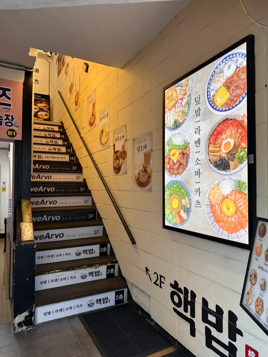 핵밥 건대본점 계단 앞에 붙은 메뉴판