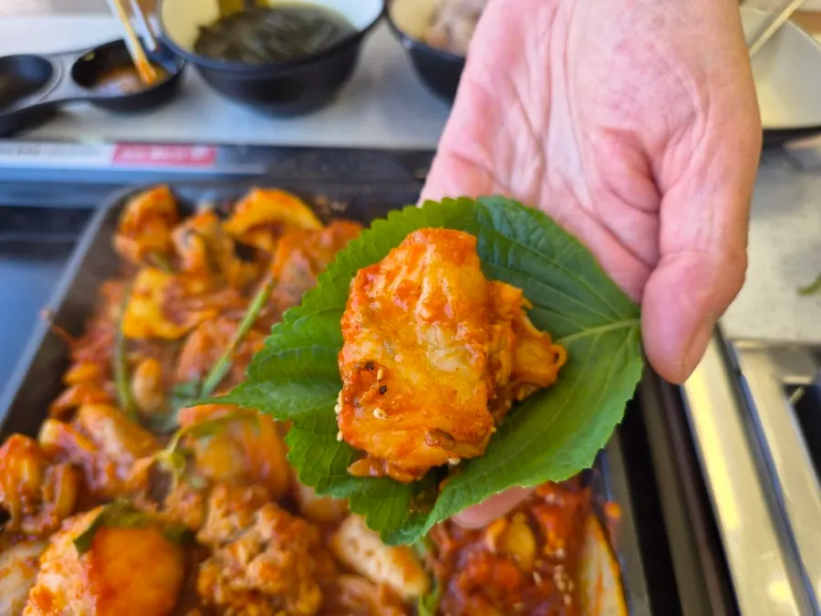 A piece of angler fish stew placed on a perilla leaf
