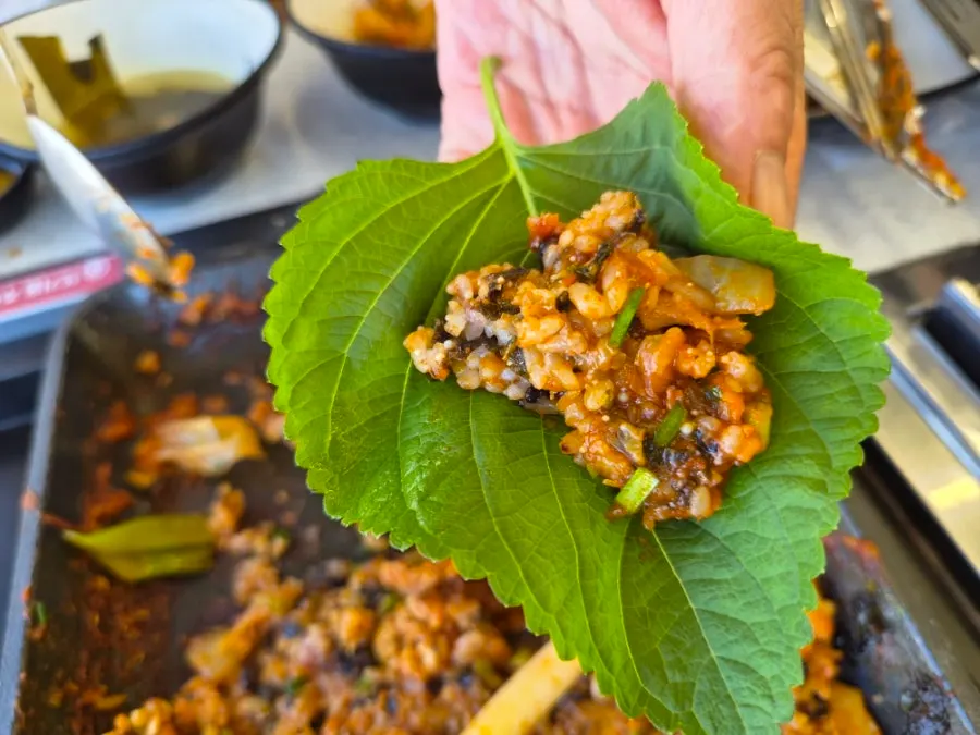 Fried rice served with white kimchi and perilla leaves