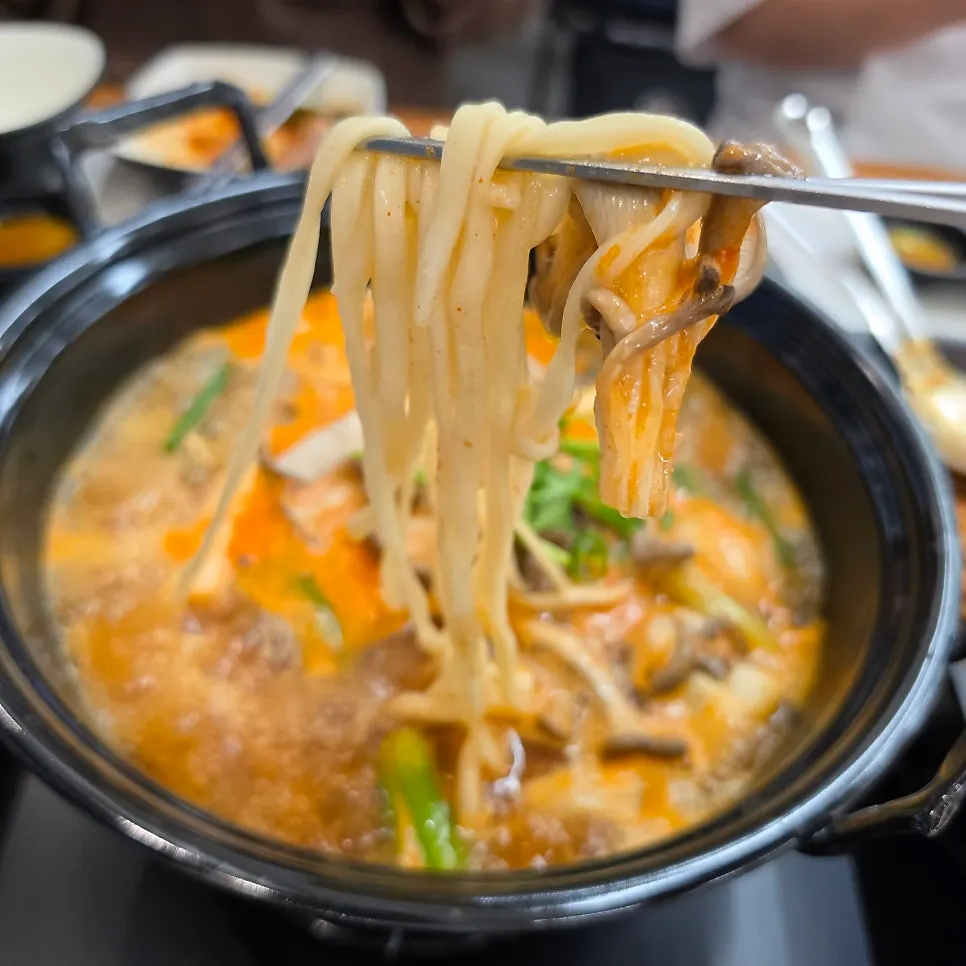 Mushroom kalguksu topped with whole shiitake mushrooms