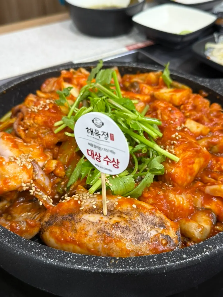 Plate of white kimchi and braised potato side dishes