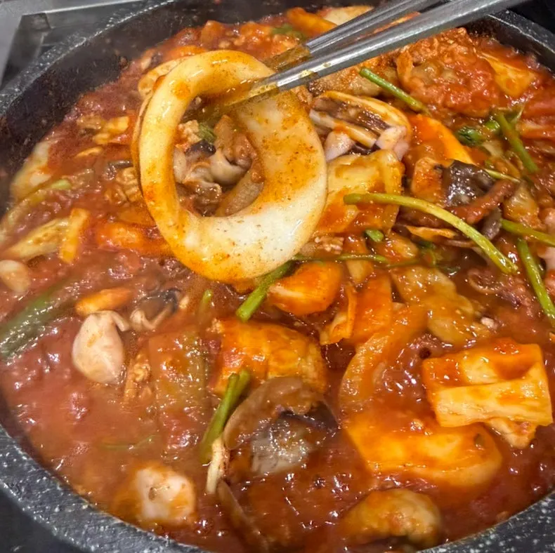 Plate of seafood stew showing whole squid texture