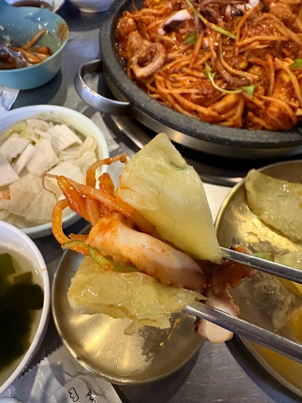 Vertical shot of monkfish being lifted with chopsticks