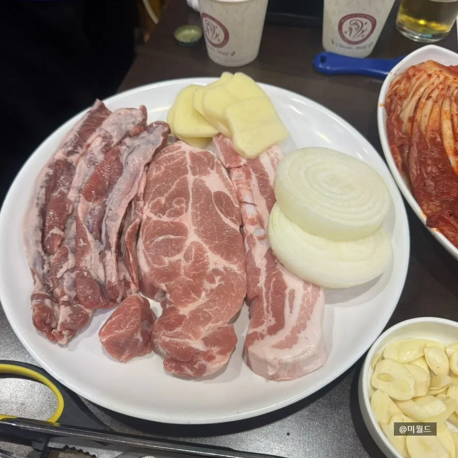 Plate of raw pork belly, pork neck, and skirt meat