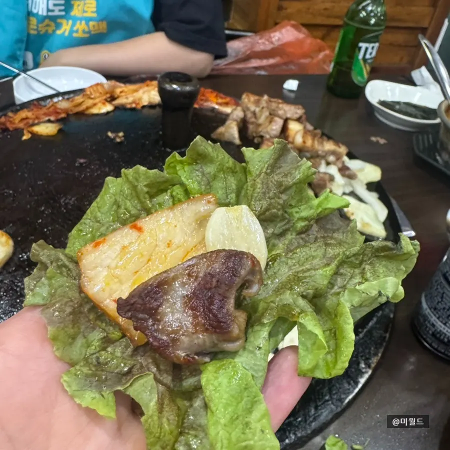 A wrap of meat with pickled radish and kimchi