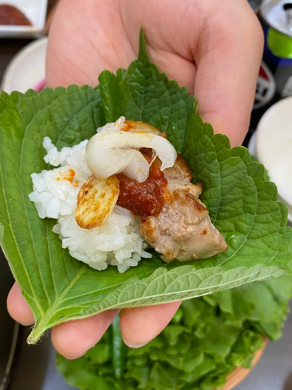 A perilla leaf wrap with rice and pork belly