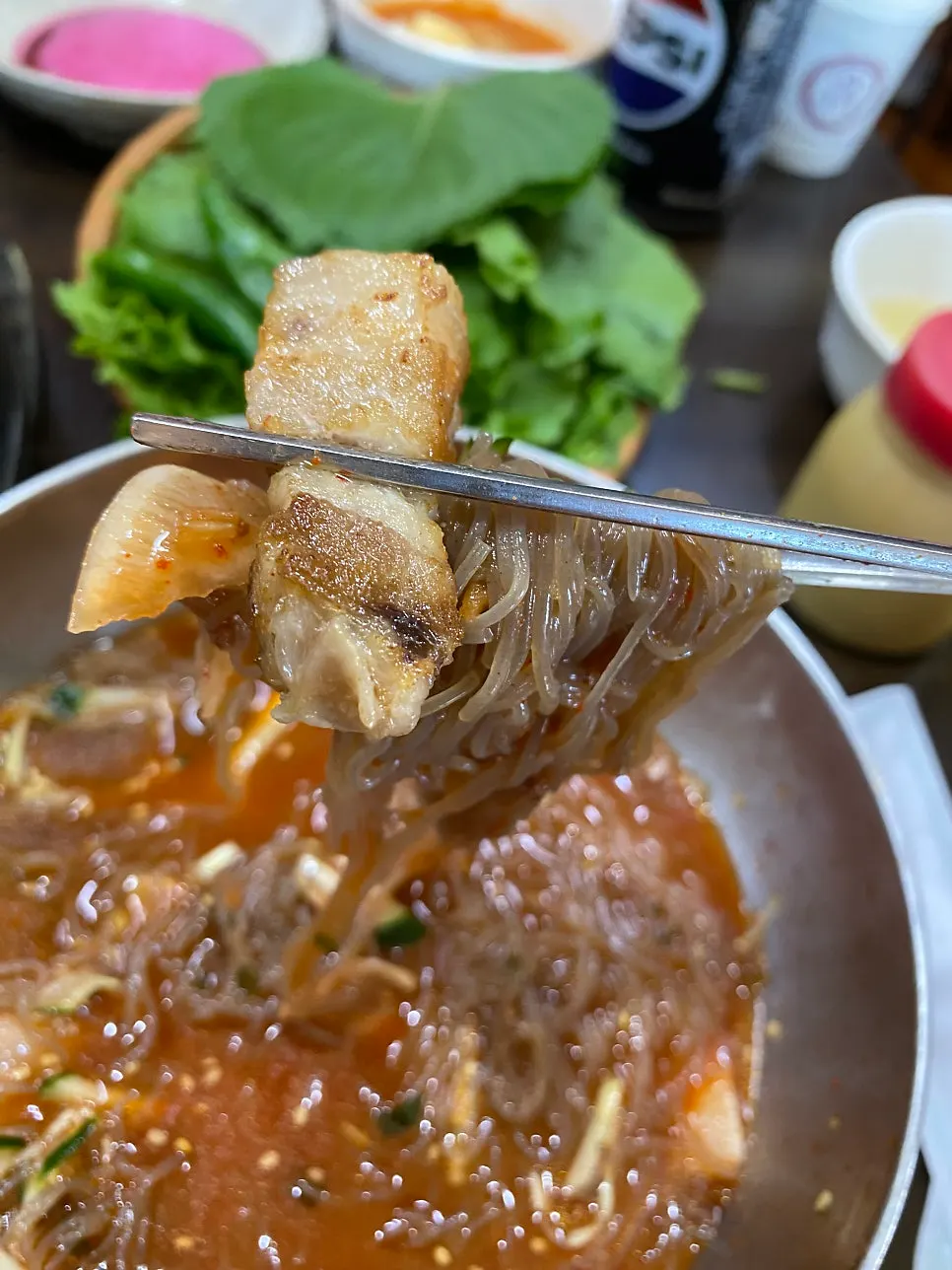 Chewy naengmyeon noodles lifted up